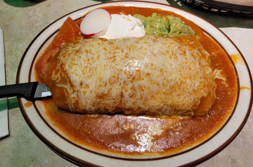 Burrito turned indulgent: covered in rich red sauce and gooey melted cheese. Credit: u/Food_Films_Fire via r/food